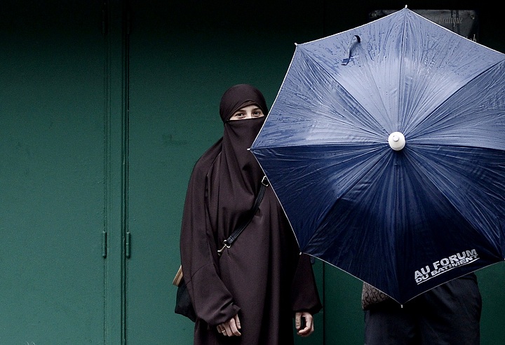 A woman wearing a niqab poses next to her husband in Paris, on June 29, 2014.