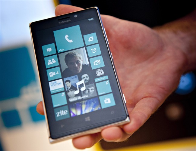 This Aug. 15, 2013 file photo shows Nokia's Lumia 925 phone at the flagship store of Finnish mobile phone manufacturer Nokia in Helsinki, Finland. On Thursday, July 17, 2014, as part of an announcement to cut up to 18,000 jobs over the next year, Microsoft said it would discontinue its Nokia X phones and shift future product designs to its Lumia line of Windows phones.