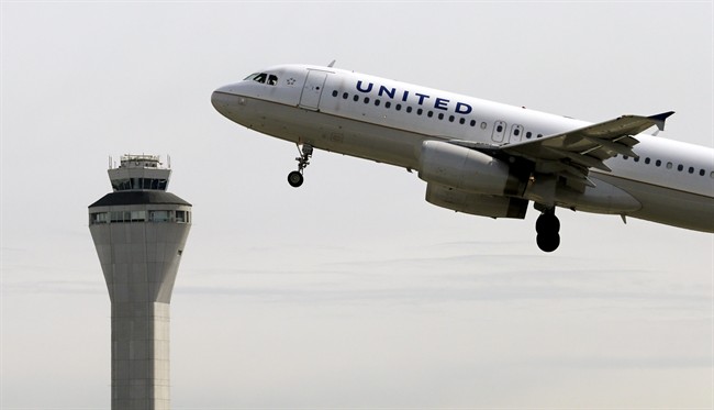 In this April 23, 2013 file photo, a United Airlines jet departs in view of the air traffic control tower at Seattle-Tacoma International Airport in Seattle. 