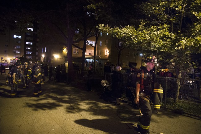 New YorkCity firefighters work at the scene of a fire at public-housing high-rise early Sunday, July 6, 2014, in the Brooklyn borough of New York. A fire department spokesman says Lt. Gordon Ambelas died at Woodhull Medical Center late Saturday night after he was pulled from the building unconscious. 