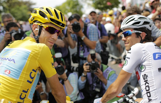 Italy's Vincenzo Nibali, wearing the overall leader's yellow jersey, and France's Thibaut Pinot, wearing the best young rider's white jersey, wait for the start of the twenty-first and last stage of the Tour de France.