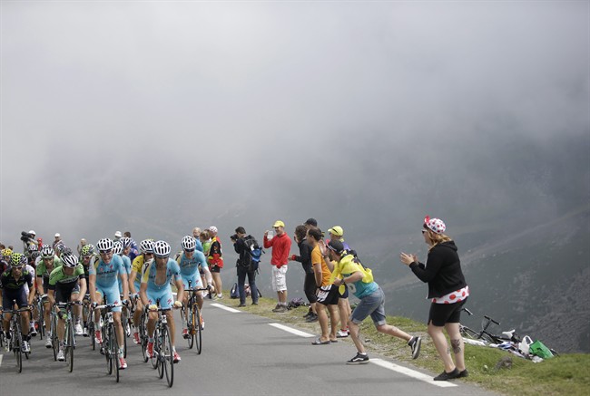 The pack with Italy's Vincenzo Nibali, wearing the overall leader's yellow jersey, climbs Tourmalet pass in the mist during the eighteenth stage of the Tour de France cycling race over 145.5 kilometers (90.4 miles) with start in Pau and finish in Hautacam, Pyrenees region, France, Thursday, July 24, 2014.