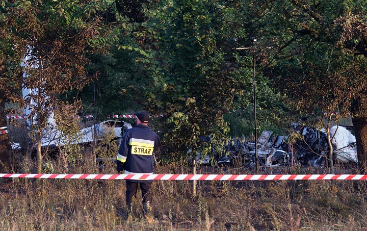 A firefighter examines the crash site of a plane near the village of Topolow in Poland, Saturday, July 5, 2014. 