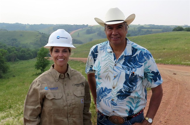 Miranda Jones, vice president of environmental safety and regulatory at Crestwood Midstream Partners, and Tex Hall, chairman of the Three Affiliated Tribes, pose for a photo near the site of a pipeline spill near Mandaree, N.D., Wednesday, July 9, 2014. A pipeline owned by a Crestwood subsidiary leaked around 1 million gallons of saltwater. Some of that liquid entered a bay that leads to a lake that is used for drinking water by the Three Affiliated Tribes. 
