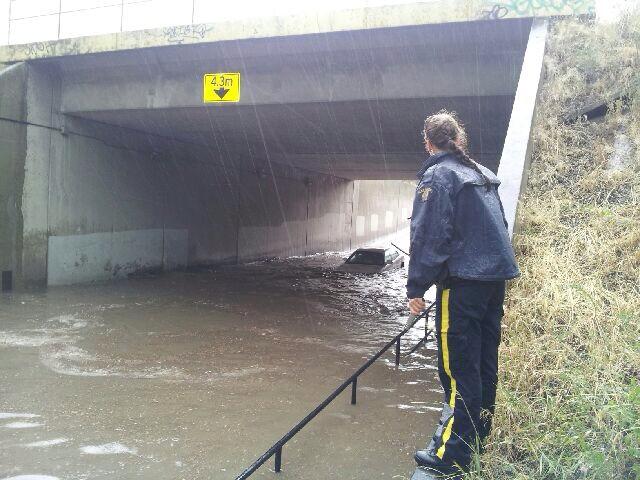 RCMP officers trying to figure out how to access trapped vehicle. Credit: Jeff Schenderling on twitter.
