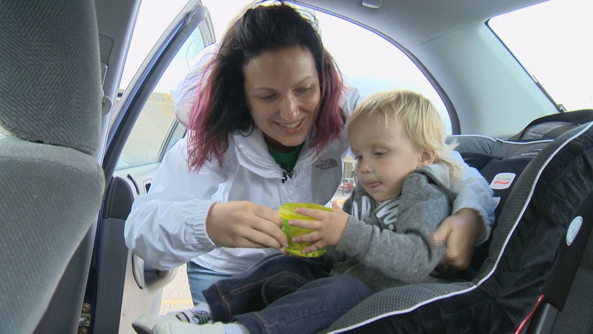 Michele Ailsby secures her two-year-old, Elias, in a toddler seat on Saturday.