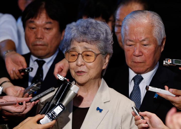 Shigeru Yokota, right, and his wife Sakie, center, parents of a daughter, Megumi who was abducted by North Korean agents in 1977, are surrounded by reporters following their meeting with Japan's Prime Minister Shinzo Abe at Abe's official residence in Tokyo, Friday, July 4, 2014.
