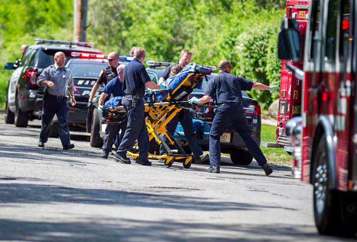 In this Saturday, May 31, 2014 photo, rescue workers take a stabbing victim to the ambulance in Waukesha, Wisconsin.
