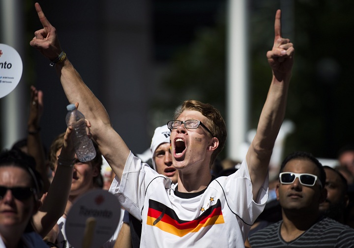 A German supporter celebrates following Germany's victory over Argentina in the World Cup final on Front Street in Toronto on Sunday, July 13, 2014. 