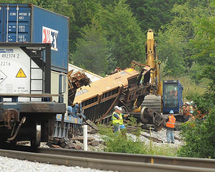 Workers use heavy machinery while they remove derailed train cars from the tracks in Wytheville, Va., Tuesday, July 15, 2014, the day after more than a dozen cars of a Norfolk Southern train derailed. 