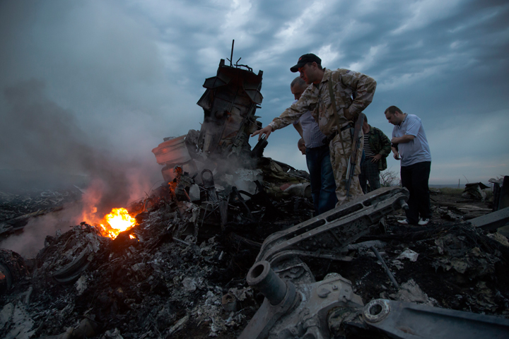 People inspect the crash site of a passenger plane near the village of Grabovo, Ukraine, Thursday, July 17, 2014.