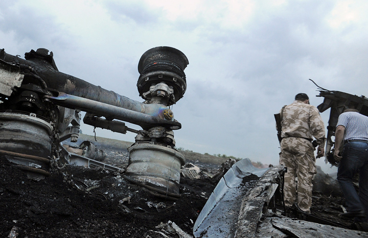 A man wearing military fatigues stands next to the wreckage of the Malaysian airliner carrying 295 people from Amsterdam to Kuala Lumpur after it crashed, near the town of Shaktarsk, in rebel-held east Ukraine, on July 17, 2014.