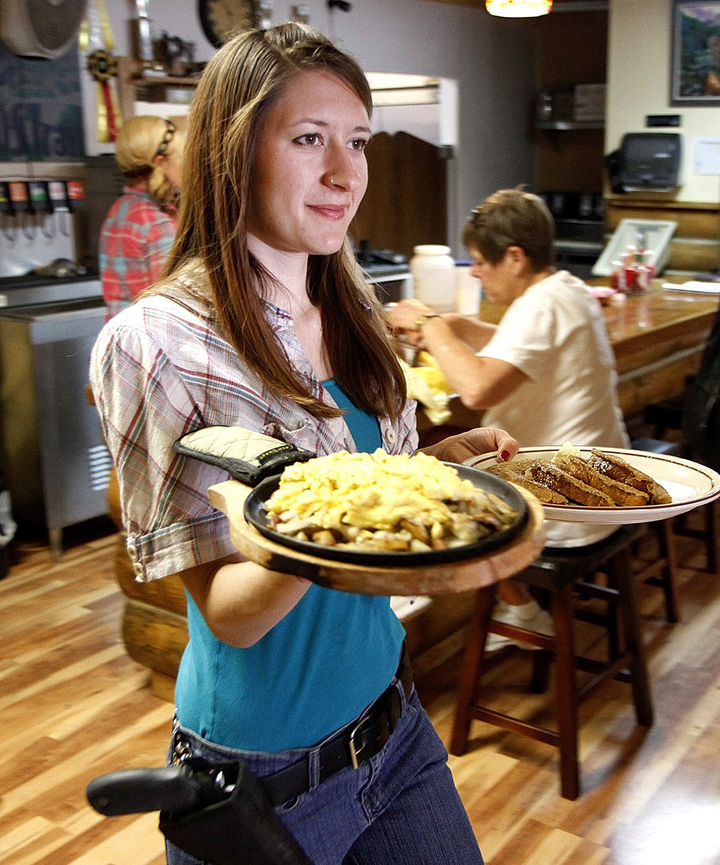 Jessie Spaulding a waitress at the Shooters Grill in Rifle, Colo., brings food to a table, June 23. 2014.