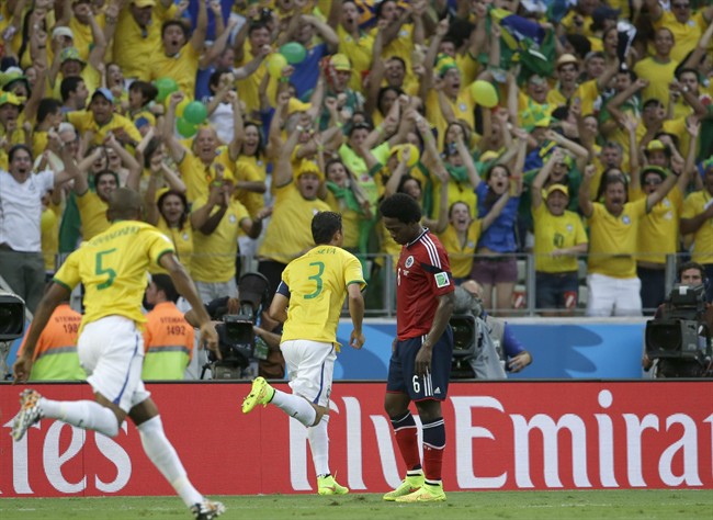 Brazil's Thiago Silva, center, celebrates after scoring the opening goal during the World Cup quarterfinal soccer match between Brazil and Colombia at the Arena Castelao in Fortaleza, Brazil, Friday, July 4, 2014.