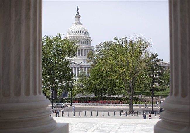 The U.S. Capitol building is seen through the columns on the steps of the Supreme Court in Washington.