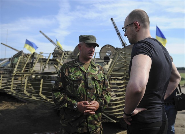 Ukrainian Prime Minister Arseniy Yatsenyuk, right, talks to an officer during inspection of a Ukrainian Army position outside the eastern town of Slovyansk, Ukraine, Wednesday, July 16, 2014. An Air Force fighter jet has been shot down by an air-to-air missile fired from a Russian plane, a spokesman for Ukraine's Security Council said Thursday.