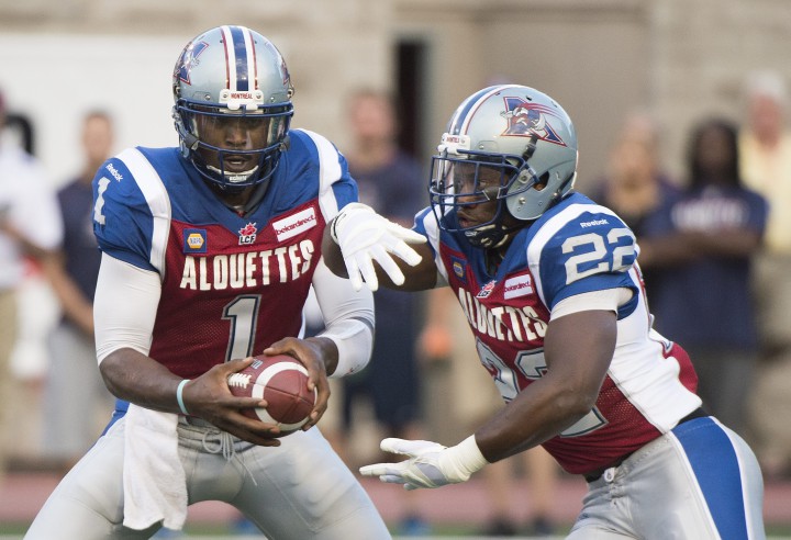 Montreal Alouettes' quarterback Troy Smith, left, hands off to Steven Lumbala during first half CFL football action against the B.C. Lions in Montreal, Friday, July 4, 2014.