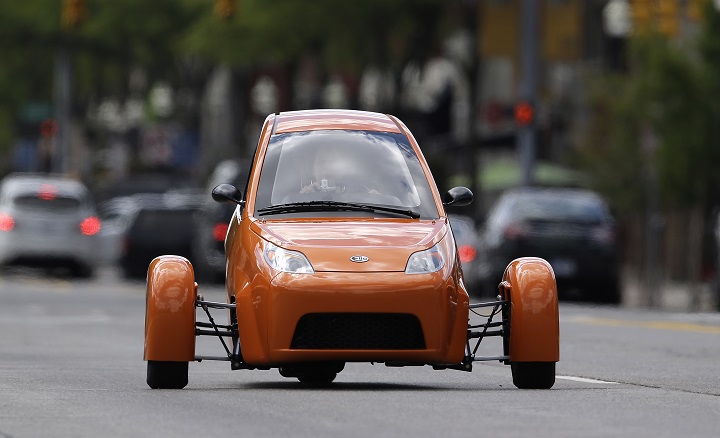 The Elio, a three-wheeled prototype vehicle, is shown in traffic in Royal Oak, Mich., Thursday, Aug. 14, 2014. Instead of spending $20,000 on a new car, Paul Elio is offering commuters a cheaper option to drive to work. His three-wheeled vehicle The Elio will sell for $6,800 car and can save on gas with fuel economy of 84 mpg. (AP Photo/Paul Sancya).