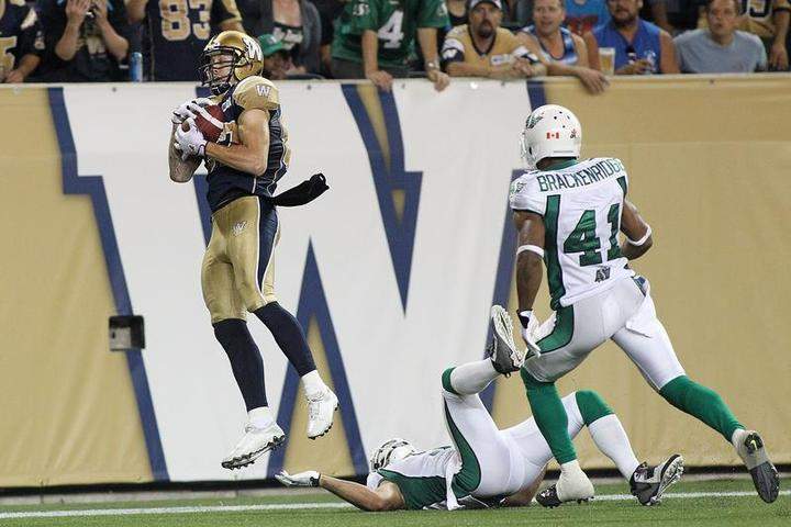 Rory Kohlert #87 of the Winnipeg Blue Bombers grabs the ball for a touchdown in second half action in a CFL game against the Saskatchewan Roughriders at Investors Group Field on August 7, 2014 in Winnipeg, Manitoba, Canada.
