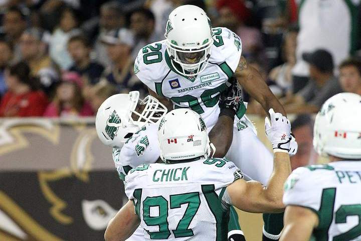WINNIPEG, MB - AUGUST 7: Terrell Maze #20 of the Saskatchewan Roughriders is congratulated by teammates after scoring a touchdown in second-half action against the Winnipeg Blue Bombers in a CFL game at Investors Group Field on August 7, 2014 in Winnipeg, Manitoba, Canada.