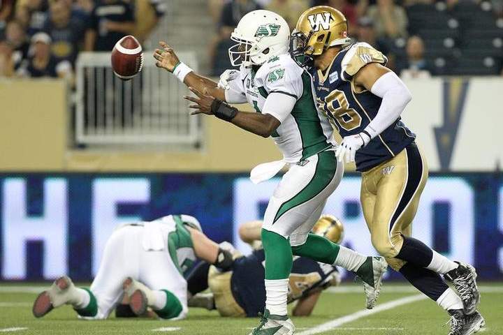 Jason Vega knocks the ball out of the hands of former Saskatchewan Roughriders quarterback Darian Durant during a game on Aug. 7, 2014.