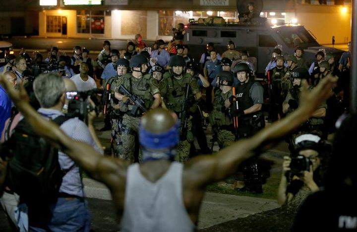 A demonstrator raises his arms before police officers move in to arrest him on August 19, 2014 in Ferguson, Missouri. 