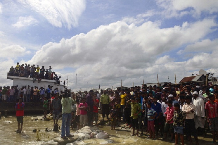 Bangladeshi onlookers gather near the scene where an overloaded ferry capsized in the Padma river in Munshiganj, some 30 kilometres (20 miles) south of the capital Dhaka, on August 4, 2014. An overloaded ferry carrying up to 200 passengers sank August 4 on a river in central Bangladesh, police said.