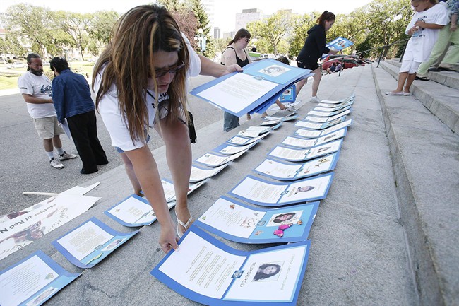 Bernadette Smith, the sister of Claudette Osborne who has been missing since 2008, lays placards of 94 women who have been murdered or are missing in Manitoba, at the Manitoba Legislature in 2009.