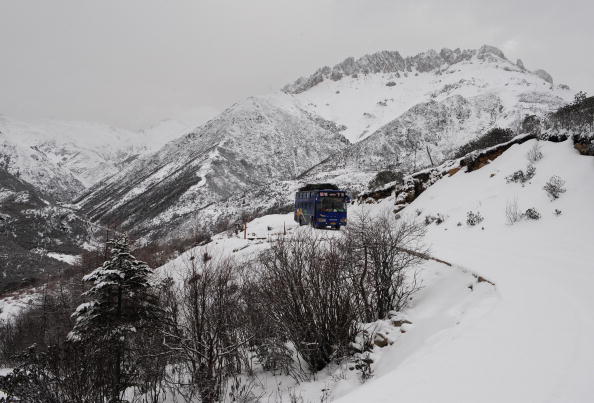 A tour bus makes its way along winding mountain roads on virgin snow leading to the last outpost town of Deqen, north of Shangrila, in the Deqen Tibetan Autonomous Prefecture on March 21, 2008 in southwest China's Yunnan province. 