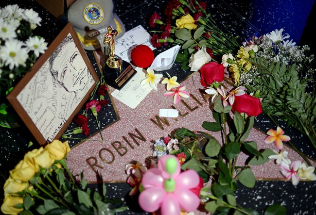 Flowers are placed in memory of Robin Williams on his Walk of Fame star in the Hollywood district of Los Angeles Monday, Aug. 11, 2014.