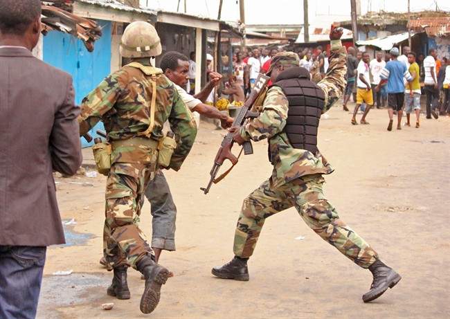 Liberian soldiers keep order at a food distribution centre Thursday, Aug. 21, 2014, at the West Point area, one of the places where the Ebola virus has claimed lives in Monrovia, Liberia. 