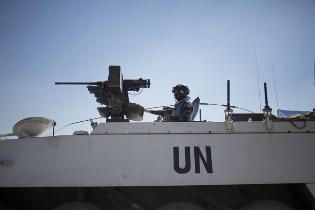 Armored vehicles from the U.N. peacekeepers of the United Nations Disengagement Observer Force, also known as UNDOF wait to cross from the Israeli controlled Golan Heights to Syria, Thursday, Aug. 28, 2014.