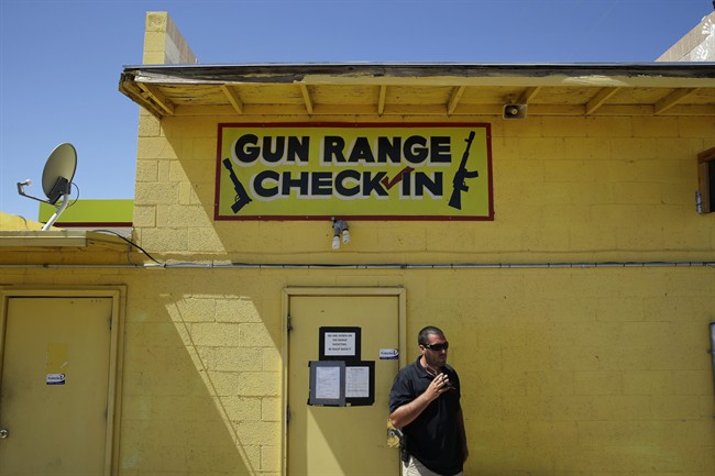 An employee smokes outside of an office for the Last Stop outdoor shooting range Wednesday, Aug. 27, 2014, in White Hills, Ariz. Instructor Charles Vacca was accidentally killed at the range by a 9-year-old with an Uzi submachine gun. 