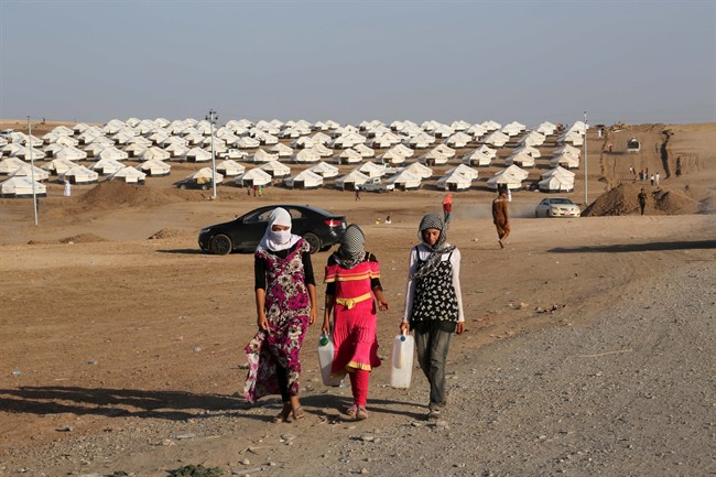 Displaced Iraqis from the Yazidi community settle at a new camp outside the old camp of Bajid Kandala at Feeshkhabour town near the Syria-Iraq border, Iraq, Friday, Aug. 15, 2014. 