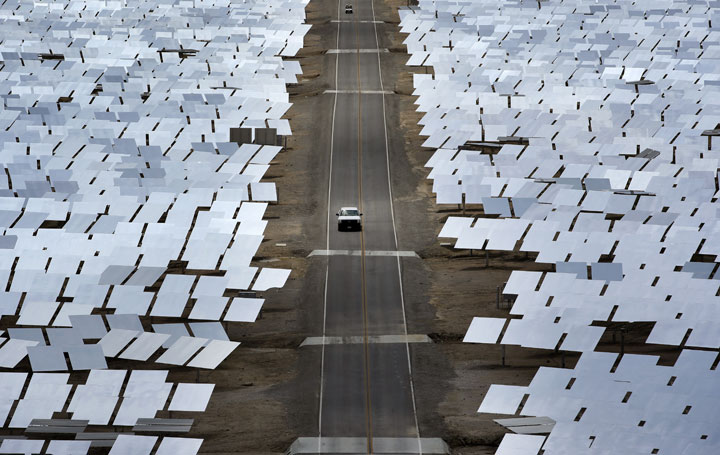 A truck drives through an array of mirrors at the Ivanpah Solar Electric Generating System near Primm, Nev. The site uses over 300,000 mirrors to focus sunlight on boilers’ tubes atop 450 foot towers heating water into steam which in turn drives turbines to create electricity.