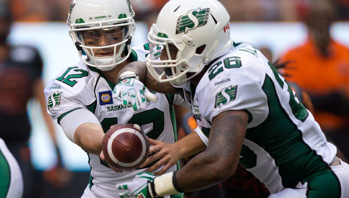 Saskatchewan Roughriders' quarterback Tino Sunseri, left, hands off to Anthony Allen during the second half of a CFL football game against the B.C. Lions in Vancouver, B.C., on Sunday August 24, 2014.
