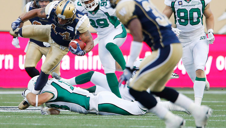 Winnipeg Blue Bombers' Aaron Woods (14) gets taken down by Saskatchewan Roughriders' Scott McHenry (18) during the first half of CFL action in Winnipeg Thursday, August 7, 2014. McHenry injured his neck in the Riders win over the B.C. Lions on Sunday.
