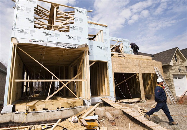 Construction workers build a new home in Oakville, Ont., on April 14.