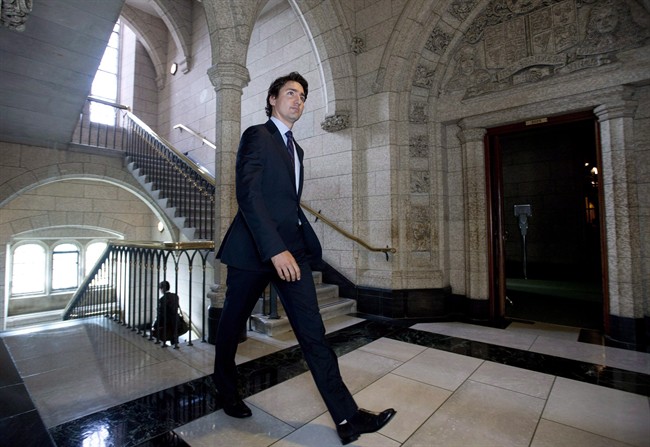 Liberal Leader Justin Trudeau makes his way to speak with the media in the foyer of the House of Commons following caucus on Parliament Hill Wednesday June 18, 2014 in Ottawa. 