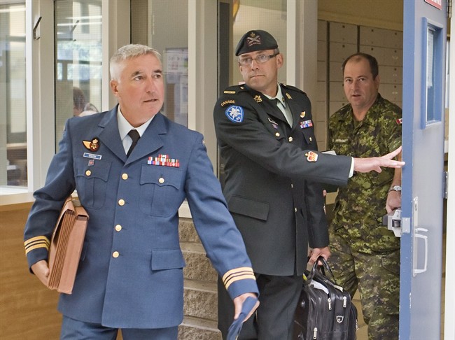 Warrant officer Andre Gagnon, centre, walks to testify at his court martial at the St-Malo Armoury Tuesday, August 12, 2014 in Quebec City with his defence counsel Major Philippe-Luc Boutin, left. 