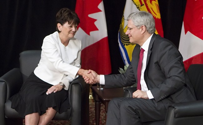 Prime Minister Stephen Harper, right, shakes hands with Jocelyne Roy-Vienneau, right, the new lieutenant governor of New Brunswick, at a news conference in Edmundston, N.B., on Friday, Aug. 8, 2014 . THE CANADIAN PRESS/Clement Allard.