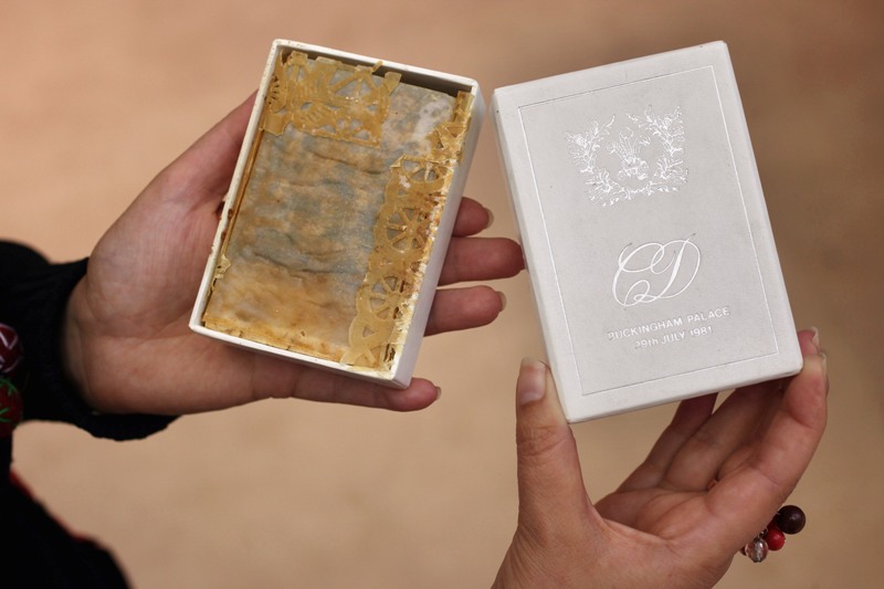 A woman holds a piece of wedding cake from the wedding of Prince Charles and Princess Diana in 1981 at the Olympia International Fine Art and Antiques Fair on June 8, 2011 in London, England.(Photo by Oli Scarff/Getty Images).