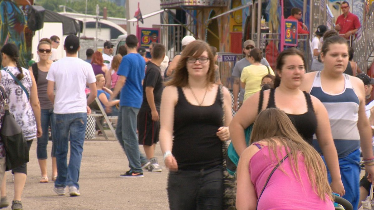 People walk the Queen City Ex grounds on Saturday. On Sunday, and organizer said the event is seeing 8-10 per cent fewer visitors due to Friday's thunderstorm.