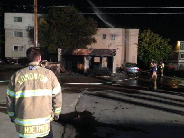 Edmonton firefighters extinguish a garage fire police believe was set by an arsonist, Friday, August 30, 2014. 