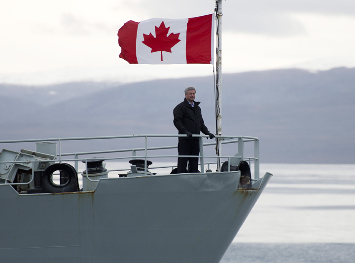 Prime Minister Stephen Harper stands on the bow of the HMCS Kingston as it sails in the Navy Board Inlet Sunday August 24, 2014. 