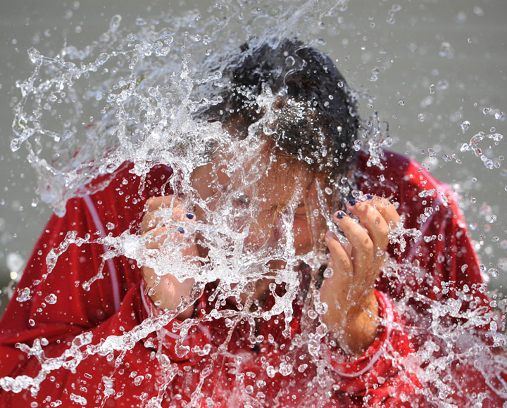 Allison Risaliti, 17, of Ebensburg, Pa., reacts to taking the ice bucket challenge, Thursday, Aug. 14, 2014, at the Ebensburg, Pa., community pool. The challenge, in which participants get a bucket of water and ice cubes dumped on their heads, raises money to fight ALS, or Lou Gehrig's disease. 