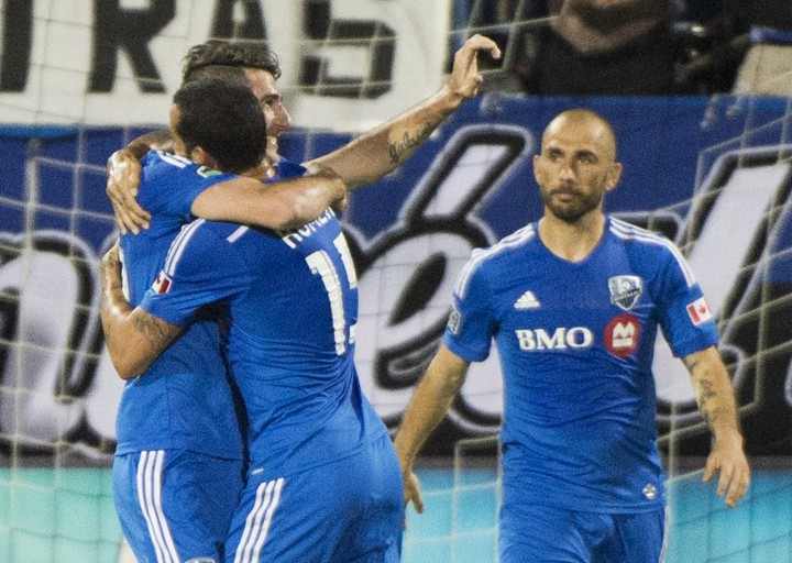 Montreal Impact's Ignacio Piatti, left, celebrates with teammates Dilly Duka (11) and Marco Di Vaio, right, after scoring against the Columbus Crew during first half MLS soccer action in Montreal, Saturday, August 30, 2014.