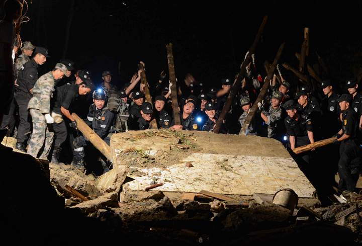 Rescue workers lift a wall that collapsed after a landslide hit Yingping village in Fuquan city in southwest China's Guizhou province Thursday Aug. 28, 2014. 