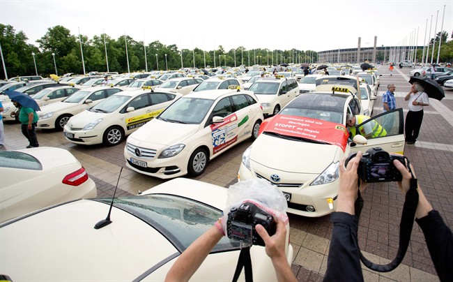 Taxi drivers gather after a protest drive against the competition from Internet and mobile applications designed for calling cabs in Berlin, Germany. Berlin taxi drivers are now celebrating a decision by authorities to ban the ridesharing service Uber from operating in the city.