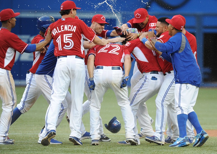 Toronto Blue Jays' Jose Bautista celebrates with teammates after hitting a walk off single against the Detroit Tigers during the 19th inning in Toronto on Sunday August 10, 2014.